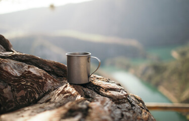 Steel camping mug on the wood at canyon viewpoint