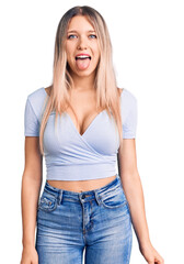Fototapeta premium Young beautiful blonde woman wearing casual clothes sticking tongue out happy with funny expression. emotion concept.