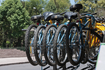 row of bicycles parked on a city street, rental bicycle parking, means of transportation