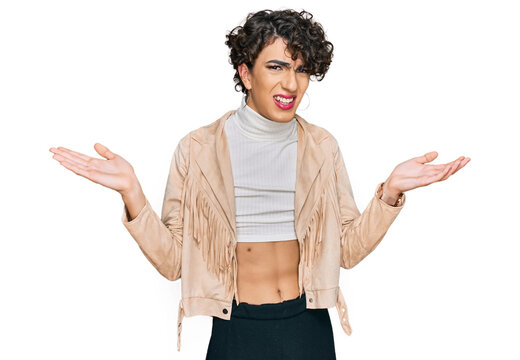 Handsome man wearing make up and woman clothes clueless and confused with open arms, no idea concept.