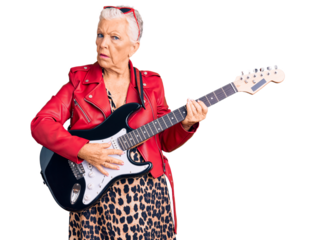 Senior beautiful woman with blue eyes and grey hair wearing a modern look playing electric guitar in shock face, looking skeptical and sarcastic, surprised with open mouth