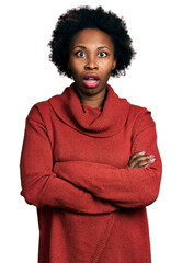 African american woman with afro hair with arms crossed gesture afraid and shocked with surprise...