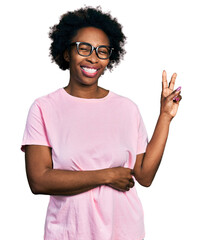 African american woman with afro hair wearing casual clothes and glasses smiling with happy face...