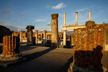 Ruins and columns of the ancient Roman city of Pompeii during sunset.