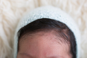 Tiny little newborn human baby head forehead pate