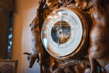 Close up view of intricate barometer on wooden frame with chamois figures. German weather scale...
