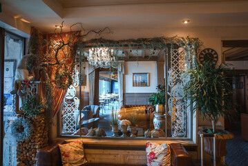 Elegant interior space with rustic wooden wall, decorative tapestry, cozy seating area, and...