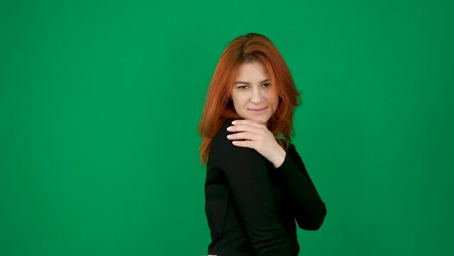 tenderness pleasant positive emotions hug yourself with your arms sway from side to side imagine dream visualize squint your eyes feel shy lower your eyelashes smile red-haired girl on green studio