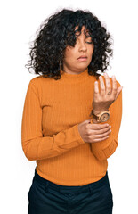 Young hispanic woman wearing casual clothes suffering pain on hands and fingers, arthritis...