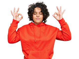 Young hispanic woman with curly hair wearing casual sweatshirt relax and smiling with eyes closed doing meditation gesture with fingers. yoga concept.