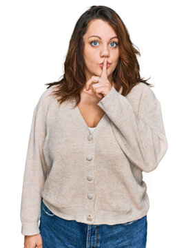 Young plus size woman wearing casual clothes asking to be quiet with finger on lips. silence and secret concept.