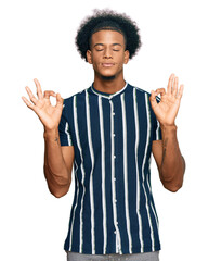 African american man with afro hair wearing casual clothes relax and smiling with eyes closed doing meditation gesture with fingers. yoga concept.