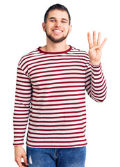 Young handsome man wearing striped sweater showing and pointing up with fingers number four while smiling confident and happy.