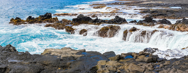 Waves Washing Over The Rocky Volcanic Shoreline at Wawalili Beach, Wawaloli Beach Park, Hawaii...