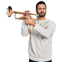 Young hispanic man with beard playing trumpet clueless and confused expression. doubt concept.
