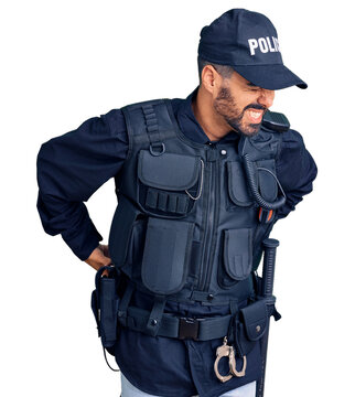 Young hispanic man wearing police uniform suffering of backache, touching back with hand, muscular pain