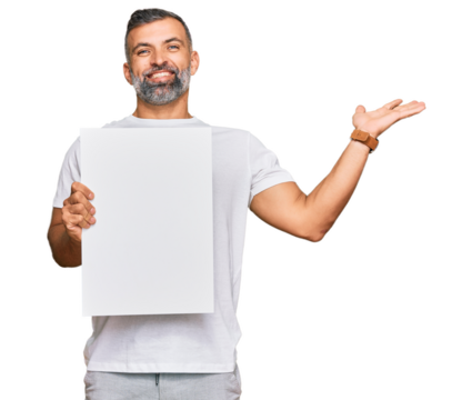 Middle age handsome man holding blank empty banner celebrating victory with happy smile and winner expression with raised hands - Powered by Adobe