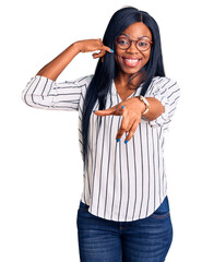 Young african american woman wearing casual clothes and glasses smiling doing talking on the...