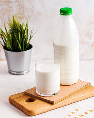 Fresh milk in a plastic bottle with a glass on a wooden board, healthy drink concept.