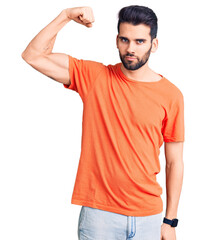 Young handsome man with beard wearing casual t-shirt strong person showing arm muscle, confident...