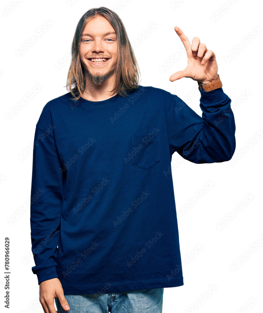 Poster Handsome caucasian man with long hair wearing casual winter sweater smiling and confident gesturing with hand doing small size sign with fingers looking and the camera. measure concept.