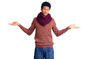 Young african american man wearing casual winter sweater and scarf clueless and confused expression...