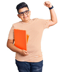 Little boy kid holding book wearing glasses strong person showing arm muscle, confident and proud...