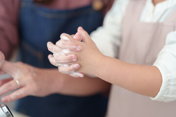 手を洗う女の子とお母さんの手元 - 780968424