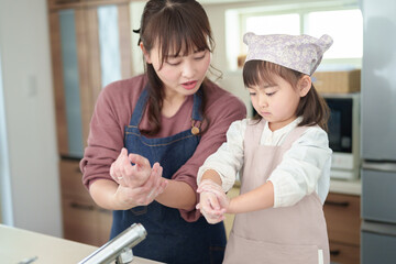 手を洗う女の子とお母さん - 780968444