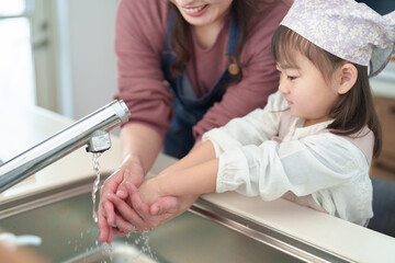 手を洗う女の子とお母さん - 780968452