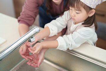 手を洗う女の子とお母さん - 780968460