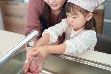 手を洗う女の子とお母さん - 780968462