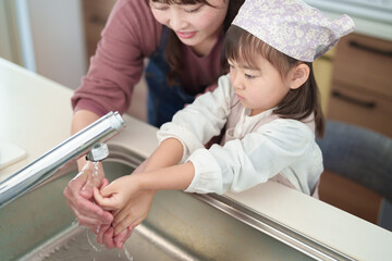 手を洗う女の子とお母さん - 780968475