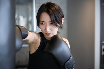 Front view of cool handsome boxer woman boxing or exercising at gym Close up