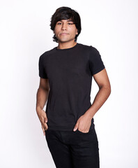 American shot of a young Latino man with both hands in the pocket of his black jeans. The...