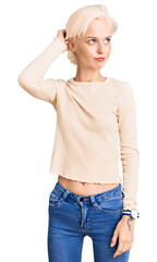 Young blonde woman wearing casual clothes confuse and wondering about question. uncertain with...