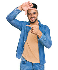 Young arab man wearing casual clothes smiling making frame with hands and fingers with happy face....