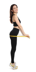 Happy young woman with measuring tape showing her slim body against white background