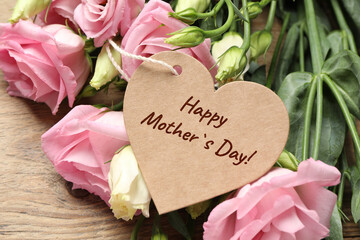 Happy Mother's Day. Heart shaped greeting label and beautiful flowers on wooden table