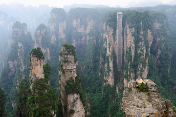Sandstone pillars rise above the lush forest of Zhangjiajie National Forest Park in Wulingyuan Scenic Area, China.