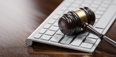 Gavel at the computer keyboard: Legal and law concept. Wooden hammer of justice and order - 780983273