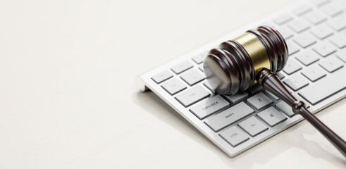 Gavel at the computer keyboard: Legal and law concept. Wooden hammer of justice and order - 780983295