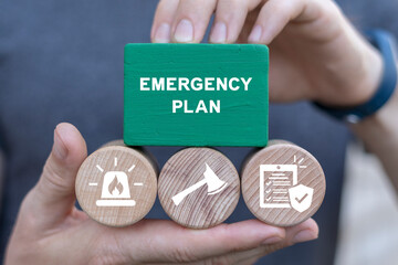 Man holding blocks with icons sees inscription: EMERGENCY PLAN. Business emergency plan concept. Checklist to do in disaster, continue business and build resilience concept. Smart emergency plan. - obrazy, fototapety, plakaty