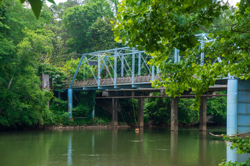 Views of calm and tranquility over  Chattahoochee river and Pace Ferry Trail Bridge. Hikers,...