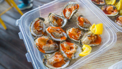 Enjoying raw seafood. Depend on the country, raw seafood can be served in different style, some will serve with crackers, tabasco, hot sauce, vinegar, lime while others serve with salt, black pepper