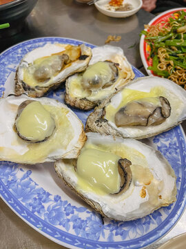 Hao nuong pho mai or chargrilled oysters with a cheese cube on top. A Vietnamese food. This seafood dish is highly popular in Vietnam. It can be both street food and fancy. The oyster is juicy, meaty