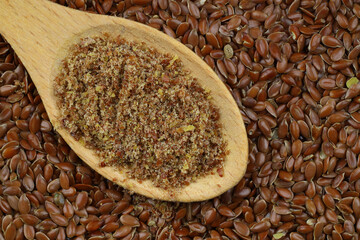 Flax seeds. Flaxseed powder in a wooden spoon. Standing on a Wooden background.