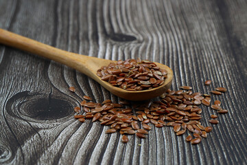 Flax seeds. Flaxseed powder in a wooden spoon. Standing on a Wooden background.