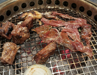 close up view of delicious asian food, pork grilling on stove