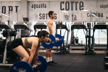 man and woman athlete training deadlift in a gym